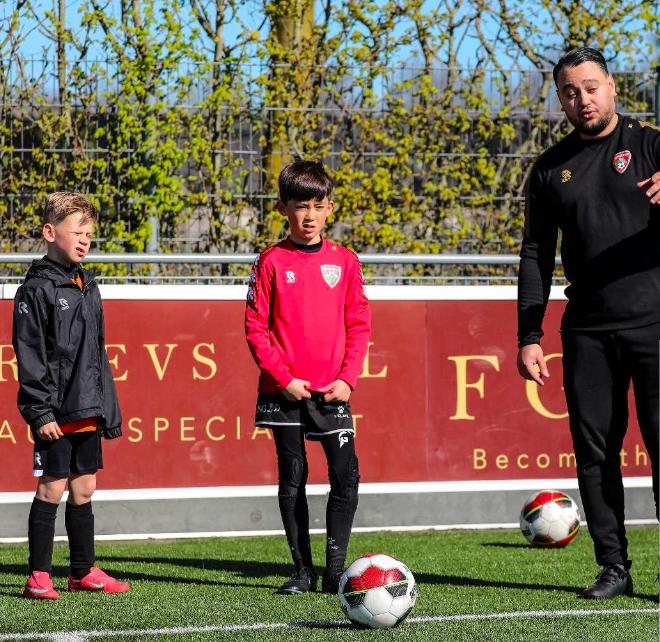 Ilyas Edir begeleidt twee jeugdspelers tijdens een oefening